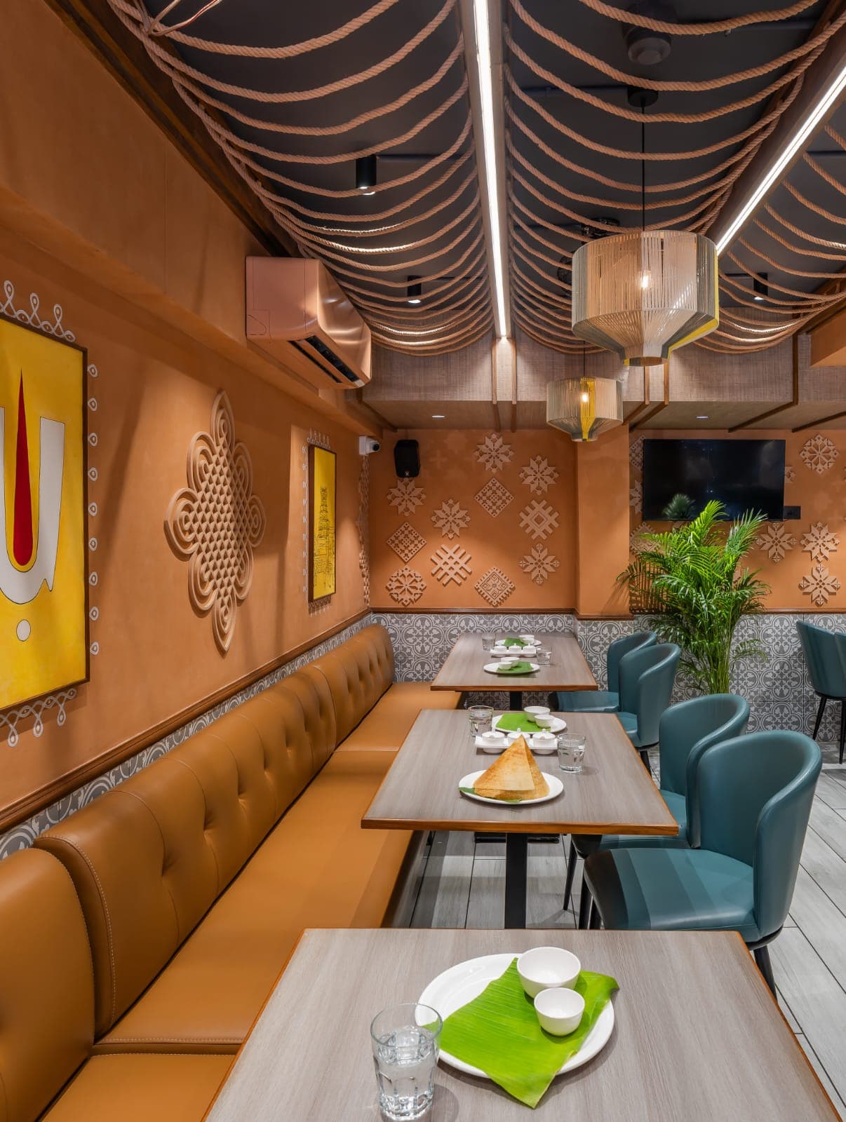 Warm, terracotta-toned restaurant interior designed by Vertex Interior Studio, with a hand-strung rope ceiling